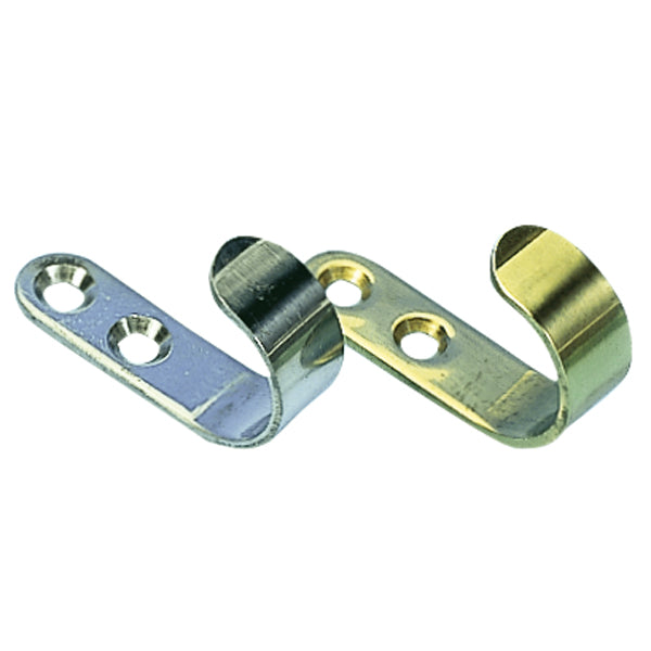 Roca tøjkrog i messing, monteret på en væg med tøj hængende på